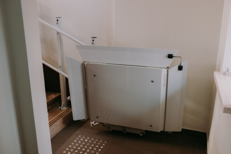 Ratiņkrēslu lifts kāpņu apakšā