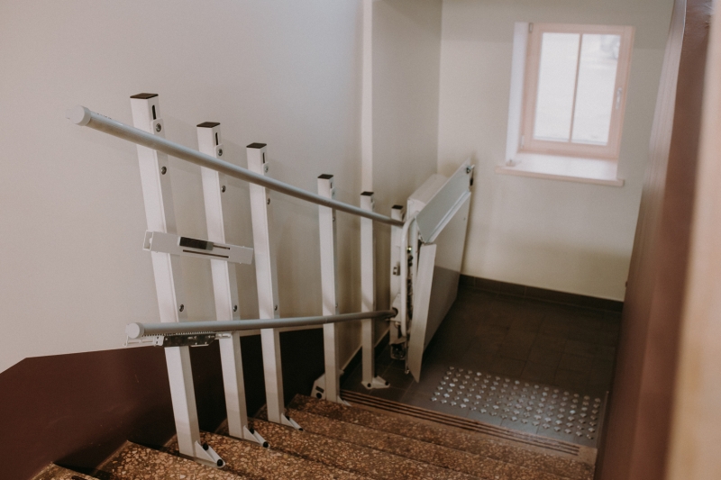 Skats uz ratiņkrēslu liftu no kāpņu augšas